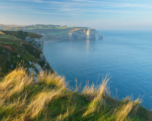 Coastline with cliffs at sunrise, Etretat, Seine-Maritime Department, Atlantic Ocean, Normandy, France Coastline with cliffs at sunrise, Etretat, Seine-Maritime Department, Atlantic Ocean, Normandy, France